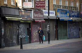 Un hombre pasa frente a las tiendas cerradas en Londres el 10 de noviembre de 2020.