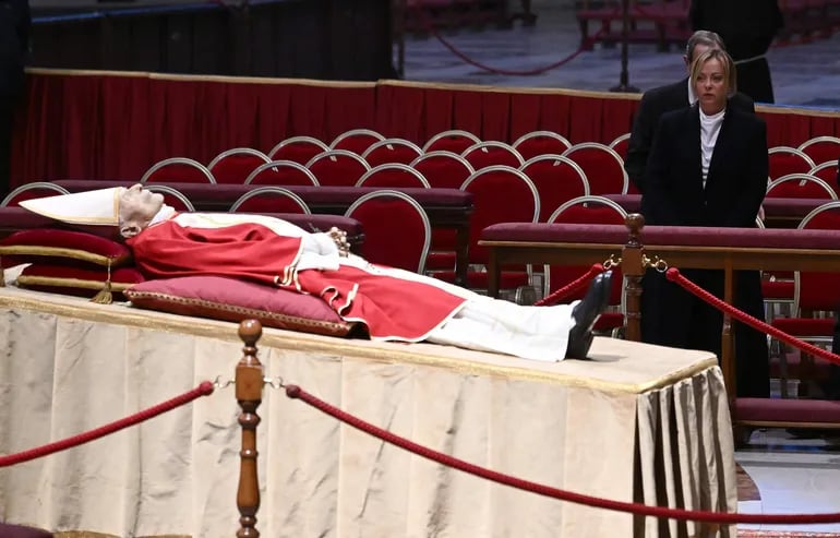 La primera ministra italiana, Giorgia Meloni (d), presenta sus respetos al fallecido papa emérito Benedicto XVI mientras visita la capilla ardiente instalada en la basílica de San Pedro del Vaticano este lunes.