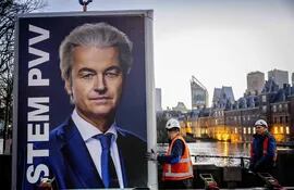 Obreros retiran un cartel del líder ultraderechista neerlandés Geert Wilders en La Haya, Países Bajos, este jueves.