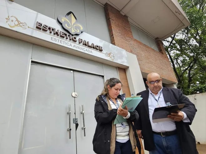 Funcionarios del Ministerio de Salud frente a la clínica de estética en Ciudad del Este clausurada luego de un supuesto caso de mala praxis.