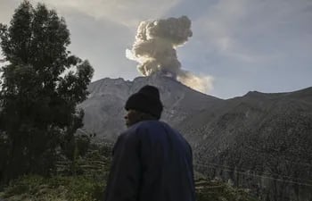 Una persona camina hoy con el volcán Ubinas de fondo, en Moquegua (Perú). El Consejo de Ministros de Perú aprobó este miércoles declarar en estado de emergencia por 60 días a los distritos cercanos al volcán Ubinas (sur), que se encuentra desde el martes en etapa eruptiva y que ha llegado a expulsar columnas de humo y cenizas de más de 5 kilómetros de altura. EFE/Stringer