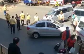 Taxistas rodean al conductor a quien los conductores de transporte alternativo cerraron el paso. uno de los taxista atacó{ó con un palo de madera.