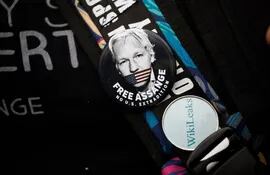 Un manifestante en las afueras de la corte de Westminster en Londres lleva un prendedor con el rostro del fundador de Wikileaks, Julian Assange.