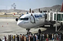 Afganos, desesperados por el regreso de los talibanes en el poder, sitiaron el aeropuerto de Kabul en un intento de alcanzar un lugar en la aeronave.  (AFP)
