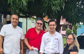 Los candidatos César "Landy" Torres (centro) y Pedro Adán Ovelar (izq.) junto con dos pobladoras. En la imagen también está un hombre de remera roja con la bolsa de alimentos.