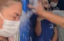 En la captura de pantalla se observa como Stiben Patrón, dirigente juvenil liberal, arroja agua a Basilisa Vázquez. Según la dirigente, el líquido tenía lavandina.
