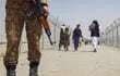 Un soldado pakistaní monta guardia mientras que un grupo de afganos retorna a su país en un cruce de frontera.