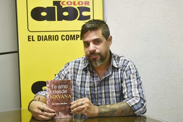 Maximiliano Mendieta exhibe la portada de su novela “Te amo desde Nirvana”, que presenta un romance musicalizado con rock.