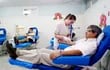 El doctor Martín Berdén, jefe de cirugía general del Instituto de Previsión Social (IPS), en momento en que una enfermera le inyecta la aguja para extraerle la sangre.