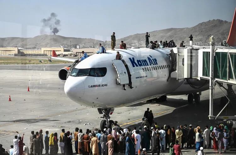 Afganos, desesperados por el regreso de los talibanes en el poder, sitiaron el aeropuerto de Kabul en un intento de alcanzar un lugar en la aeronave.  (AFP)