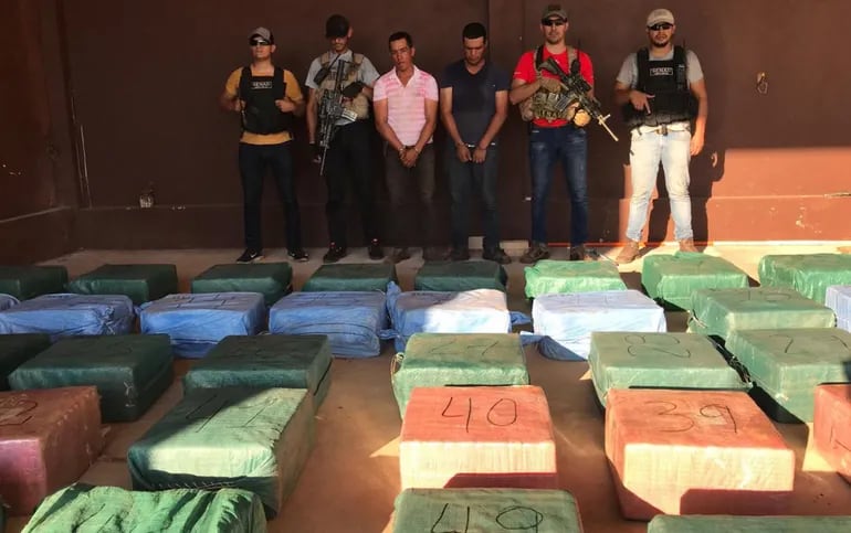 Agentes de la Senad custodian a  Pánfilo Barrios y Mario Ramón Ibáñez López, junto con la carga de cocaína incautada.