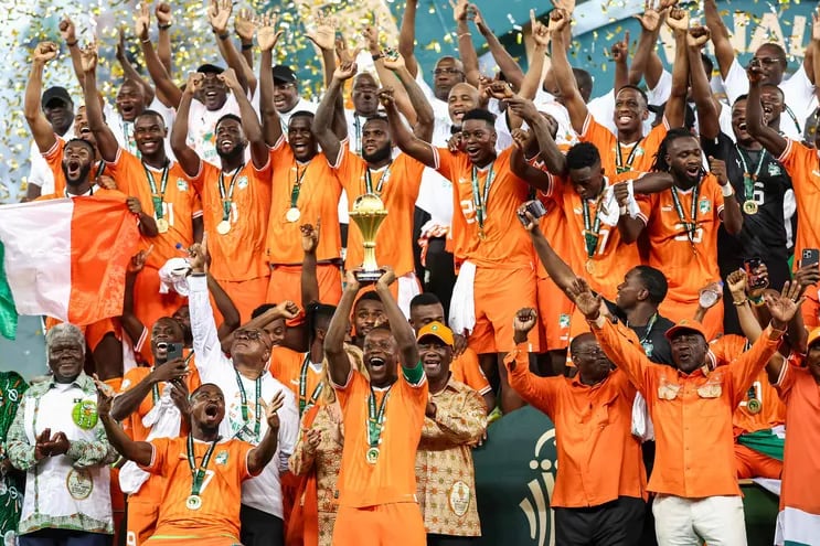 Ivory Coast's forward #15 Max-Alain Gradel (C) lifts the Africa Cup of Nations trophy on the podium after Ivory Coast won the Africa Cup of Nations (CAN) 2024 final football match between Ivory Coast and Nigeria at Alassane Ouattara Olympic Stadium in Ebimpe, Abidjan on February 11, 2024. (Photo by FRANCK FIFE / AFP)