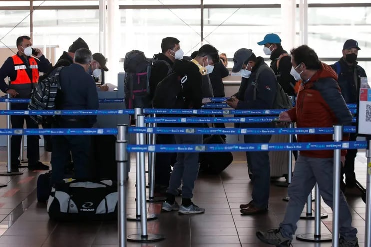 Un grupo de viajeros espera para facturar sus maletas en el aeropuerto Internacional Arturo Merino Benítez de Santiago (Chile).