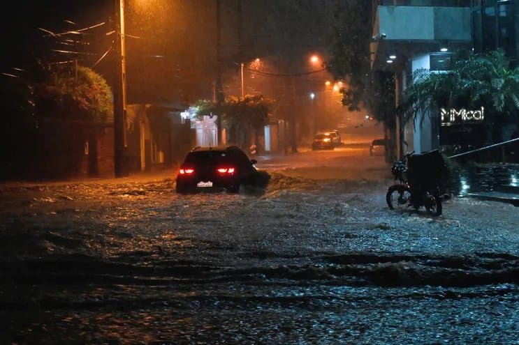 Un automóvil cruza una zona inundada por las lluvias en Asunción el jueves por la noche.