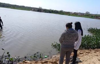 Madre de "Peño" acompaña la búsqueda del cuerpo, en el lago del barrio Santa Ana.