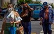 Venezolanos usan mascarillas mientras caminan en una calle de Caracas.