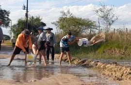 Pobladores de Laguna Itá desaguan con baldes y palas el camino vecinal que conecta la ruta principal con el distrito de San Juan de Ñeembucú.
