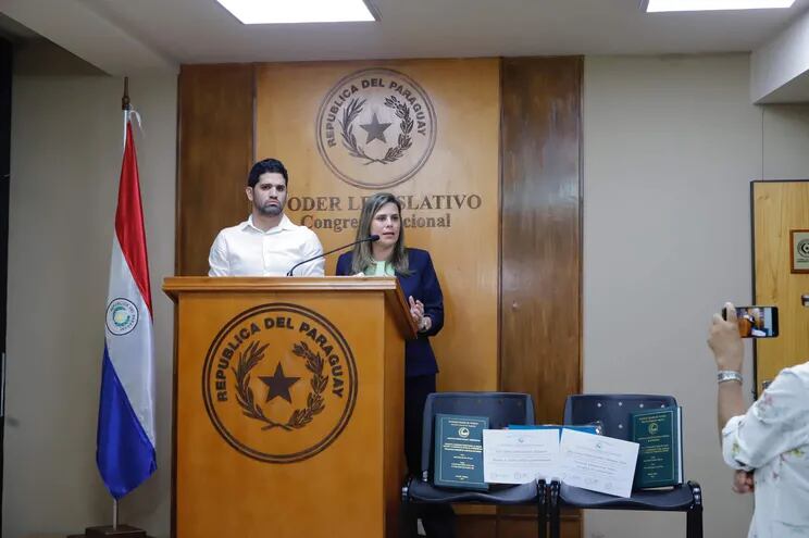 El diputado Raúl Benítez y la senadora Kattya González, ambos del PEN.  En conferencia de prensa la senadora muestra sus tesis de grado.