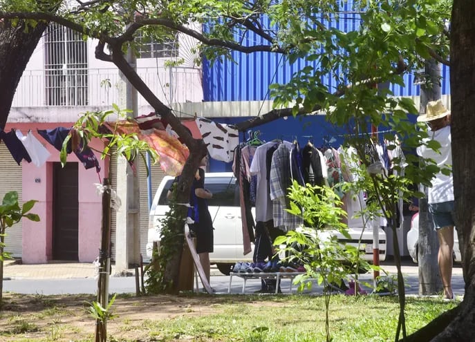 Ropa colgada entre árboles de la plaza. Vendedores ofrecen prendas usadas, sin ningún control municipal.