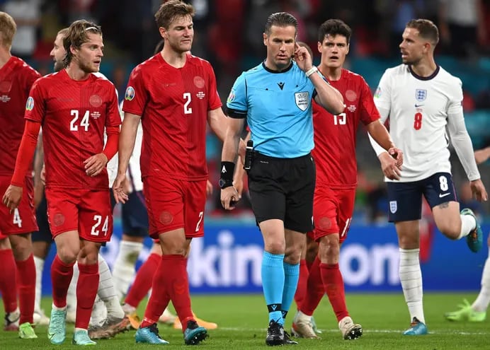 El árbitro alemán Danny Makkelie charla con la gente del VAR durante el duelo Inglaterra-Dinamarca.