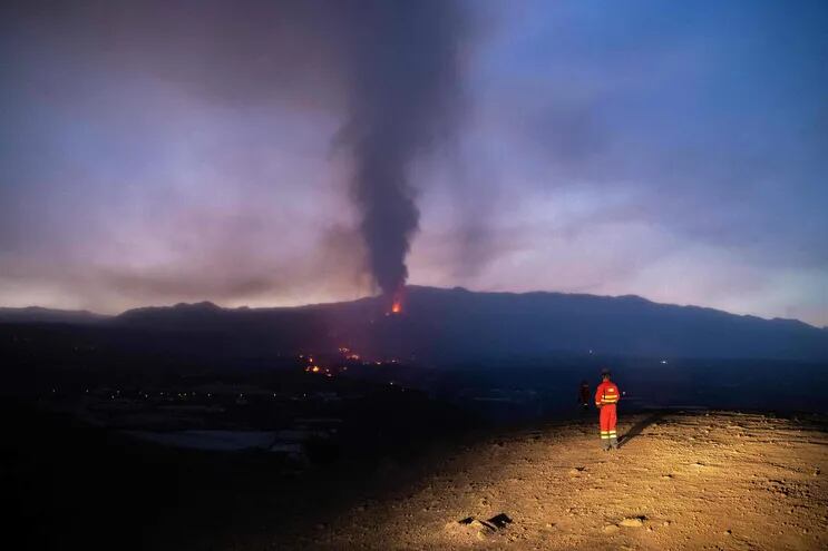 un miembro de la Unidad Militar de Emergencia monitorea el flujo de lava desde el volcán de Cumbre Vieja volcano, en la isla canaria de La Palma.