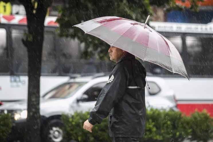 Una persona con sombrilla camina en medio de la lluvia en La Plata, provincia de Buenos Aires (Argentina).
