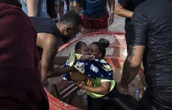 Una mujer es rescatada con su bebé en una zona inundada en la ciudad de Porto Alegre (Brasil).