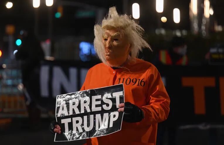 Una persona disfrazada de Donald Trump, con un cartel que reza "Arresten a Trump", se manifiesta en Nueva York, en la noche del pasado miércoles.