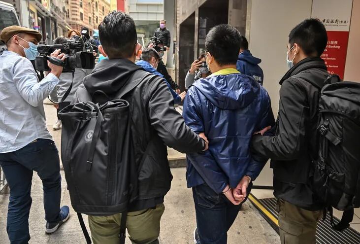 La policía llevando detenido a uno de los más de 50 activistas pro democracia de Hong Kong.
