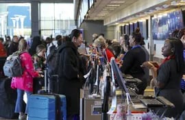 Pasajeros hacen cola para facturar su equipaje y reciben pases de embarque en el Aeropuerto Internacional Austin-Bergstrom, en Austin, Texas, EEUU.