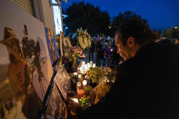 Un hombre enciende una vela frente a la foto de Halyna Hutchins, que fue recordada con una vigilia en Burbank, California.
