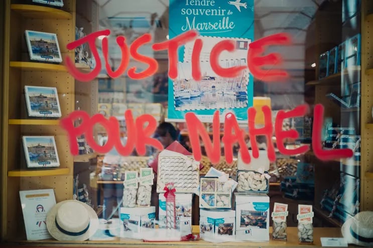 La ventana de una tienda vandalizada con un grafiti que dice "Justicia para Nahel", luego de los disturbios en el centro de Marsella, por la muerte del joven de 17 años en Nanterre por un tiro de la policía.