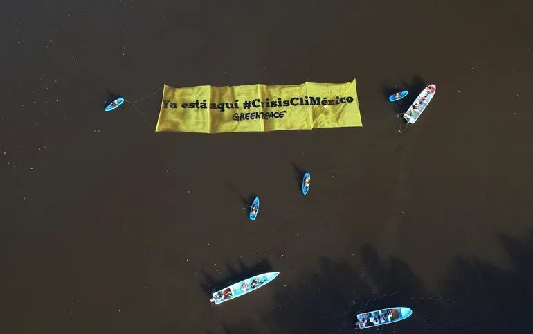 Fotografía aérea donde se observa a activistas de la organización ambientalista Greenpeace mientras protestan en una playa del municipio de Paraíso (México).