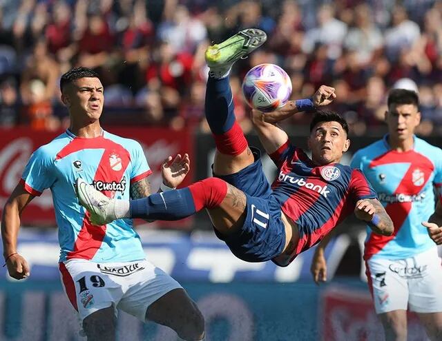 Adam Bareiro ensaya una chilena ante dos jugadores del Arsenal, durante el partido que San Lorenzo ganó ayer 1-0.