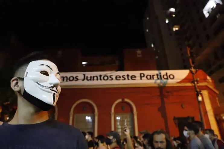 Un manifestante con una máscara de Guy Fawkes participa en una protesta hoy, frente a la sede del partido de la Asociación Nacional Republicana (ANR).