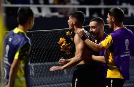 Facundo Barceló se pega al alambrado para gritar a todo pulmón el segundo gol de Guaraní, el que lo ponía de ganador en un partido que se complicó. Marcelo Palau y Kevin Lezcano lo acompañan.