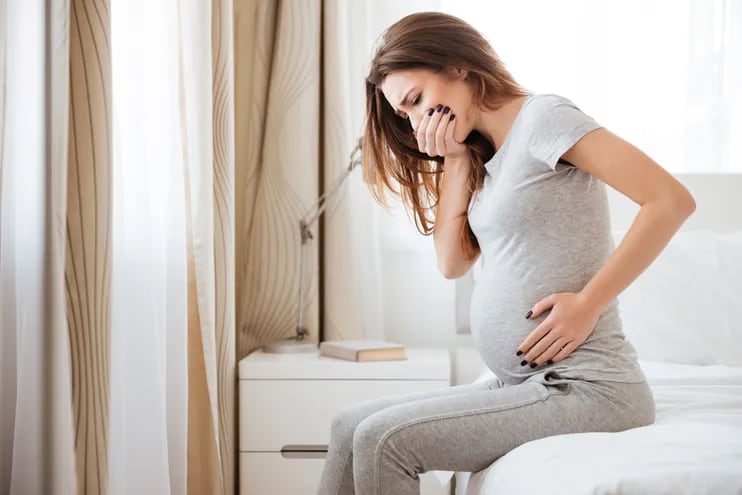 Una embarazada muestra evidentes signos de malestar estomacal.