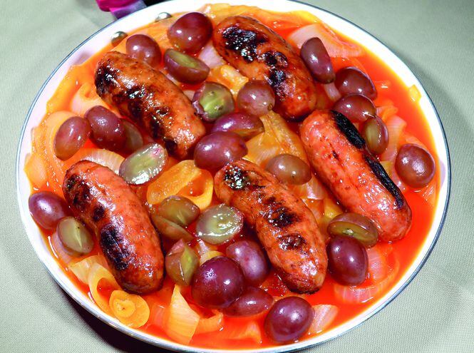 Chorizo parrillero con cebolla y uvas.
