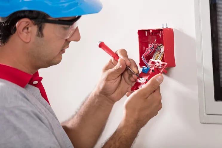 Imagen ilustrativa de un hombre instalando una alarma.