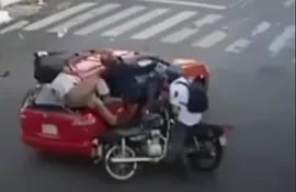 Impactante choque de dos motocicletas contra un auto en Asunción. (Captura de video de circuito cerrado).