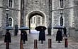 Los guardianes del castillo se refugian de la lluvia bajo los paraguas fuera del castillo de Windsor en Windsor, al oeste de Londres, el 10 de abril de 2021, el día después de la muerte del príncipe Felipe de Gran Bretaña, duque de Edimburgo, a la edad de 99 años.