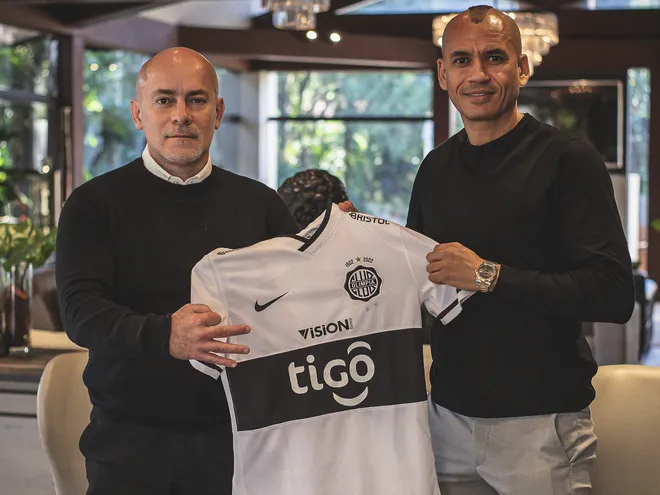 Miguel Cardona (I) y Sergio Otálvaro en la firma de la renovación hasta 2023 del lateral colombiano con el Olimpia.