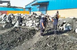 Empleados del puerto Terport de Villeta agrupan algunas de las bolsas con carbón vegetal almacenados en los contenedores de la red de tráfico de drogas.
