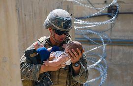 Un miembro de la misión militar de EE.UU. en Afganistán sostiene a un bebé durante la evacuación final desde Kabul, en agosto de 2021.  Es una de las imágenes más compartidas en las redes sociales.  (archivo)