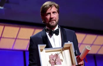El cineasta sueco Ruben Ostlund posa con la Palma de Oro, que recibió hoy en la clausura del 75 Festival de Cannes.