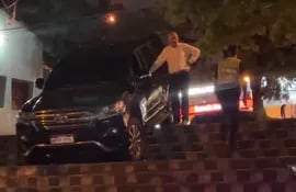 El exsenador Juan Darío Monges parado a lado de su camioneta que cayó en la escalinata de la avenida Carlos Antonio López.