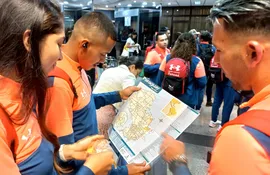 Parte de la delegación de deportistas revisando un mapa del Paraguay.