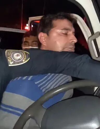 El comerciante Diosnel Villalba es forzado por dos agentes policiales a bajarse de su camioneta.