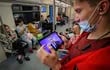 Un pasajero de metro sigue desde una tablet la tradicional Línea Directa anual del presidente de Rusia, Vladímir Putin, en la que responde a las preguntas de los ciudadanos, este miércoles en Moscú.