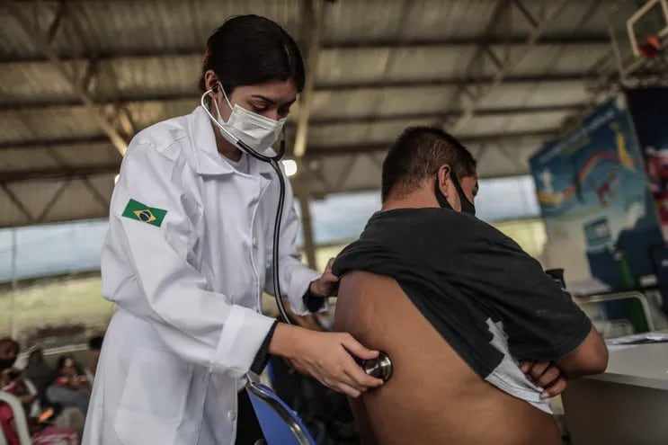 Una médica examina a un hombre en el Centro de Atención de la Gripe, hoy, en el complejo de favelas de Alemão, en Rio de Janeiro (Brasil).